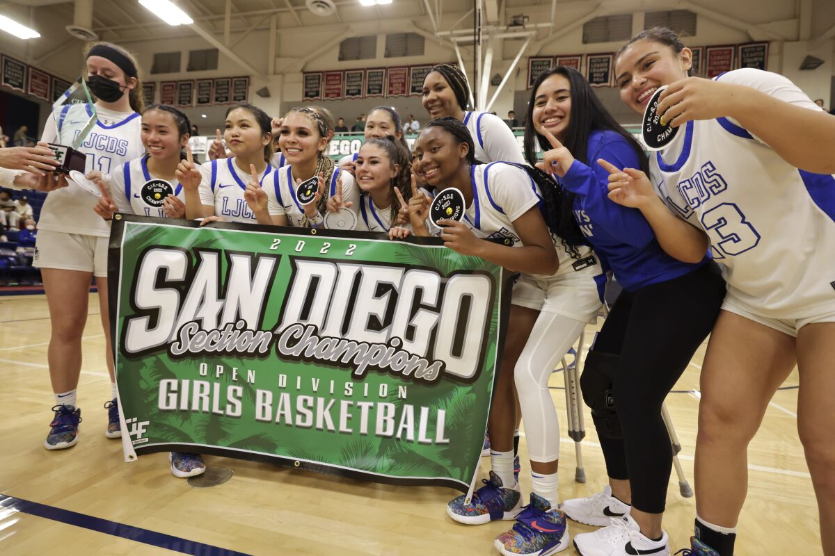 La Jolla Country Day players pose for pictures after their 68-53 win over Mission Hills on Saturday.
