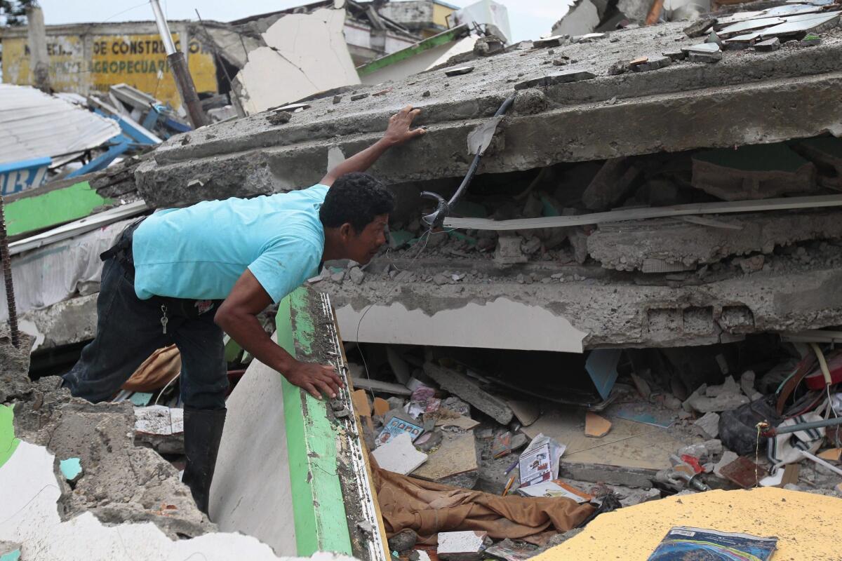 A man searches a collapsed building on Sunday in the Pedernales, Ecuador, the day after a 7.8 magnitude earthquake hit.