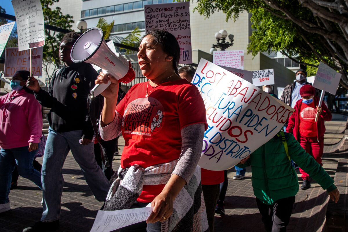 A woman holds a megaphone as she marches in a rally last month outside of Los Angeles City Hall.
