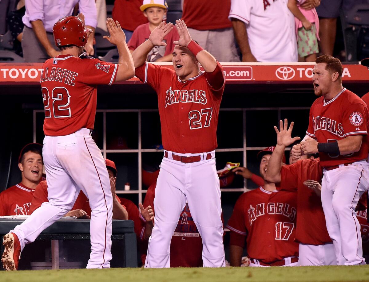 Outfielders Mike Trout (27) and Kole Calhoun (56) congratulate Conor Gillaspie after his two-run home run put the Angels ahead of the Indians in the sixth inning.