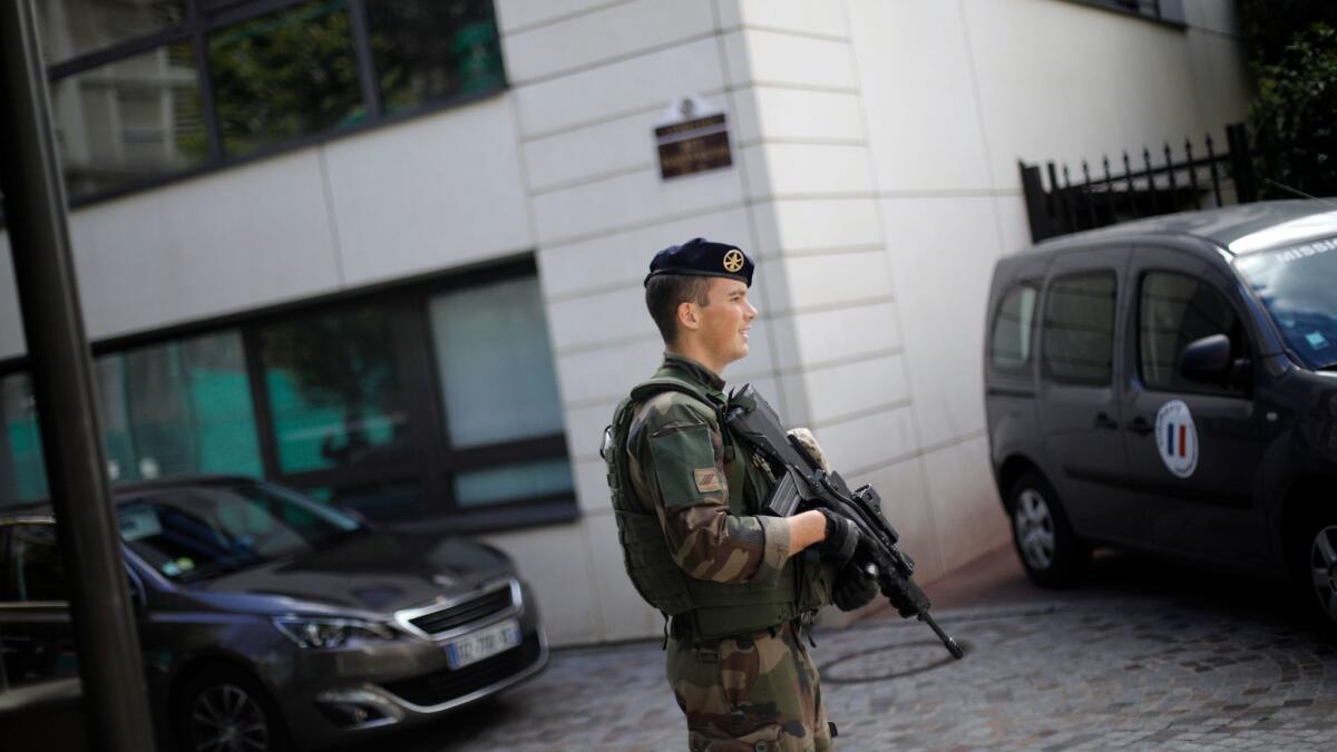 A soldier stands near the scene where fellow troops were hit and injured by a vehicle Aug. 9 in the Paris suburb of Levallois.