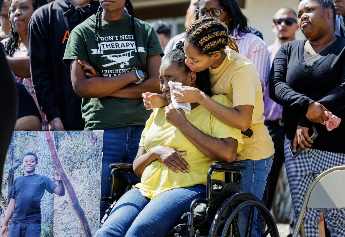 Rebecca Gainer, sister of murdered Ryan Gainer, comforts her wheelchair-bound mother, Sharon Hayward, during a news conference.