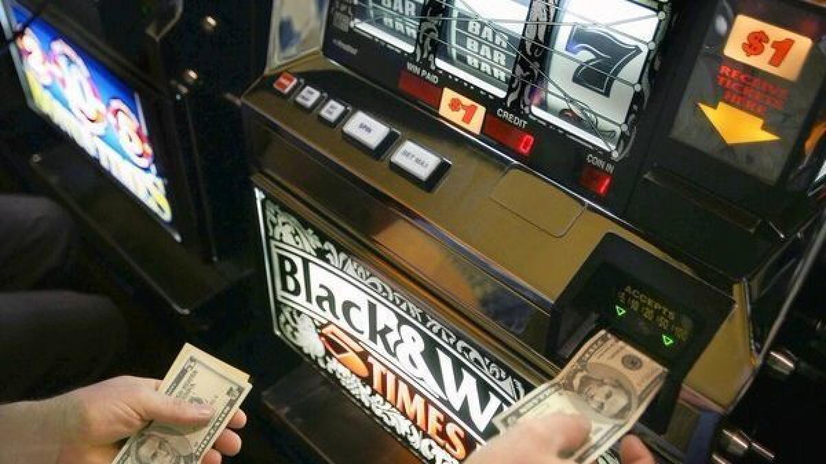 A gambler puts money into the slot machine at the Morongo Casino in Cabazon. The state's tribal casinos are expected to fight to allow sports betting only at their casinos and not in card clubs and at racetracks.
