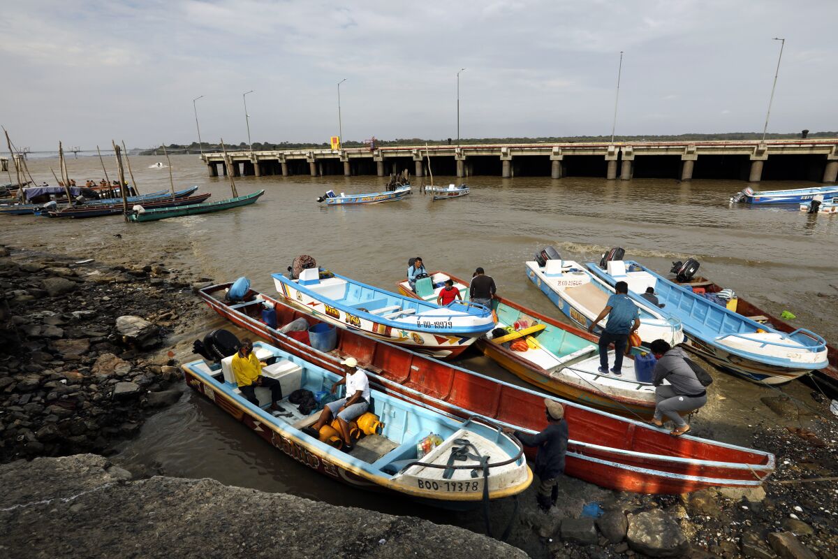 Workers unload fishing boats on the Rio Guayas in Guayaquil, Ecuador.