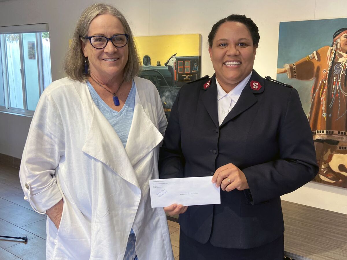 Kiwanis Club of La Jolla member Wendy Matalon presents Regina Shull with a check for $5,000 for The Salvation Army food bank.