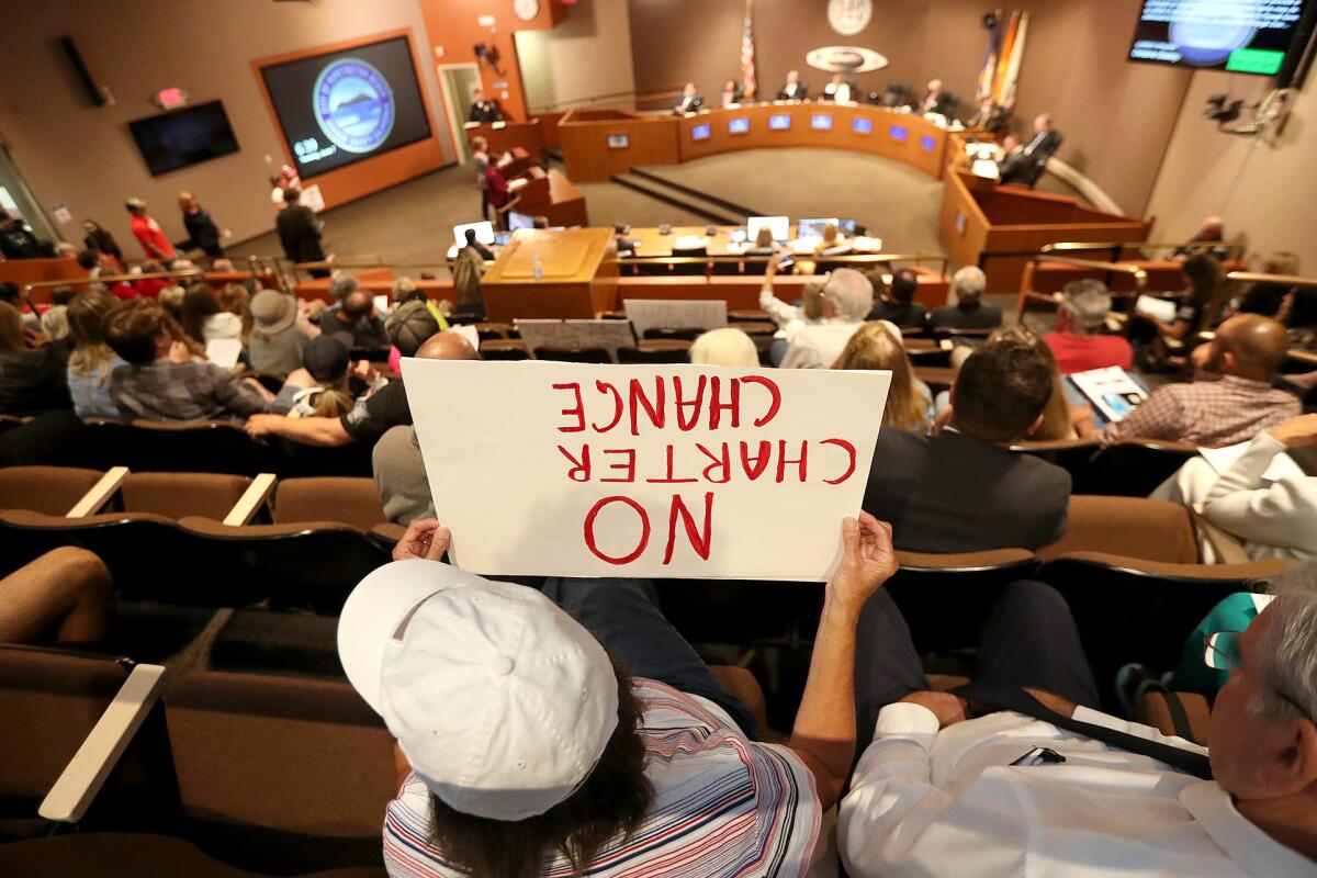 A Huntington Beach resident holds a sign illustrating her disapproval at the possible change of the City Charter.