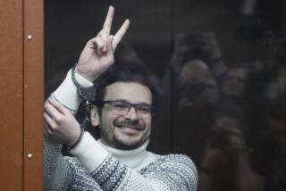 FILE - Russian opposition activist and former municipal deputy of the Krasnoselsky district Ilya Yashin gestures, smiling, as he stands in a defendant's cubicle in a courtroom, prior to a hearing in Moscow, Russia, on Dec. 9, 2022. Ilya Yashin, a prominent Kremlin critics who is serving an 8 1/2-year sentence for criticizing Russia's war in Ukraine, has been taken away from his prison to an unknown destination, his lawyer said Tuesday. (Yury Kochetkov/Pool via AP, Pool, File)