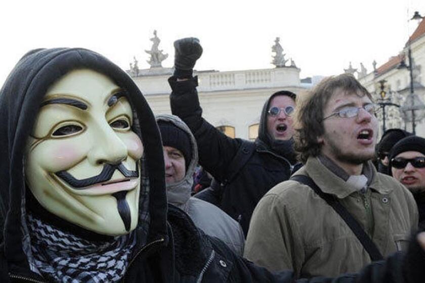 A protester wearing a Guy Fawkes mask, a symbol adopted by the hacker group Anonymous, takes part in a demonstration against the controversial Anti-Counterfeiting Trade Agreement (ACTA) in front of the Presidential Palace in Warsaw.
