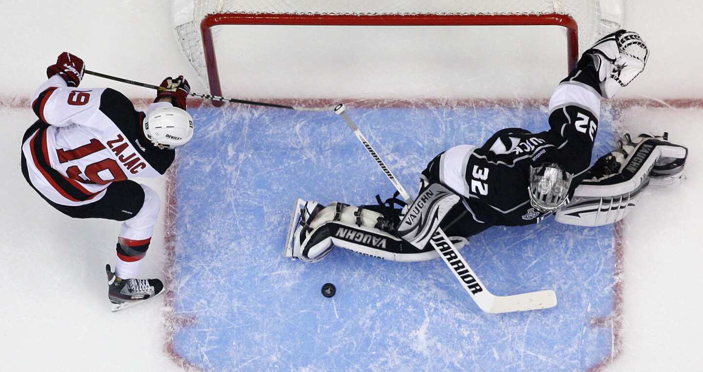Kings goalie Jonathan Quick makes a save on a shot by New Jersey forward Travis Zajac, left, during the third period of the Kings' 4-0 victory in Game 3 of the Stanley Cup Final.