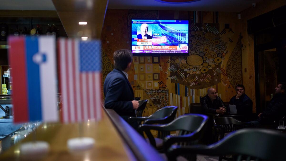 Residents of Sevnica, Slovenia, watch as U.S. presidential election results are shown on television on Nov. 9.