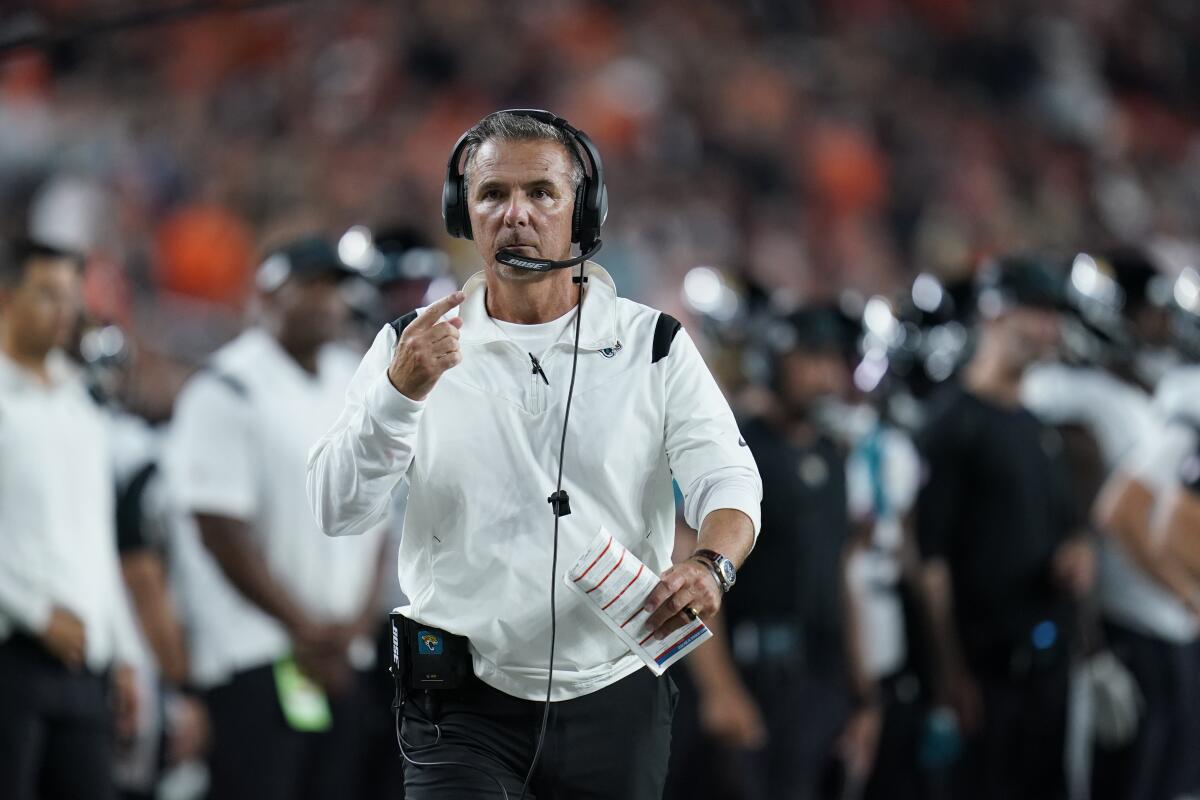 Jacksonville Jaguars head coach Urban Meyer walks with an official during the first half of an NFL football game against the Cincinnati Bengals, Thursday, Sept. 30, 2021, in Cincinnati. (AP Photo/Michael Conroy)