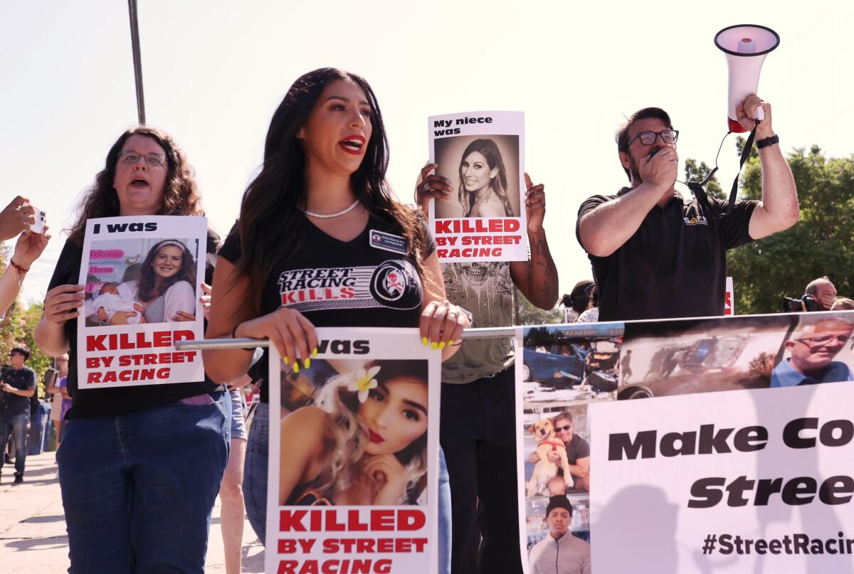 People march while carrying signs with photos of victims killed in street racing crashes