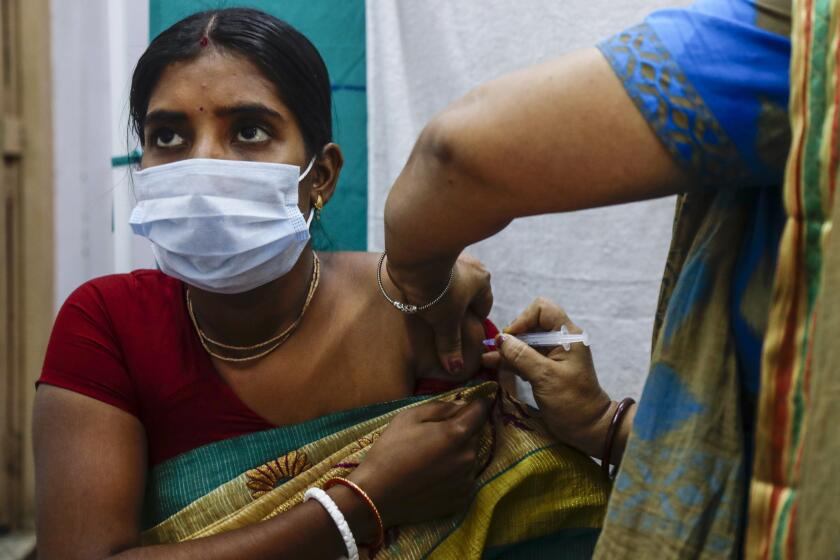 A health worker administers a dose of Covaxin COVID-19 vaccine at a health center in Garia , South 24 Pargana district, India, Thursday, Oct. 21, 2021. India has administered 1 billion doses of COVID-19 vaccine, passing a milestone for the South Asian country where the delta variant fueled its first crushing surge this year. (AP Photo/Bikas Das)