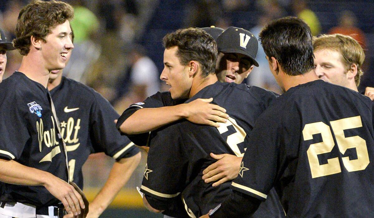Vanderbilt players surround teammate Tyler Campbell (2) after he drove in the winning run with an infield single in the 10th inning against Texas on Saturday night in a College World Series elimination game.