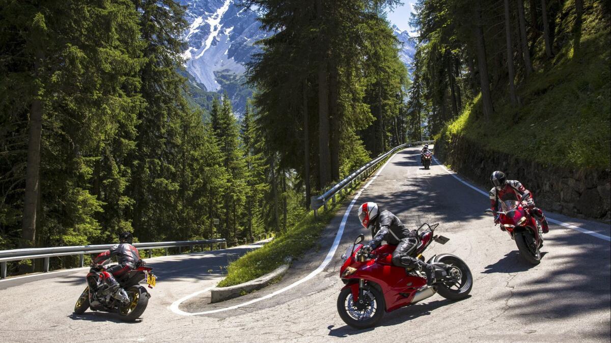 Motorcyclists lean into a curve in the Stelvio Pass in the Italian Alps.