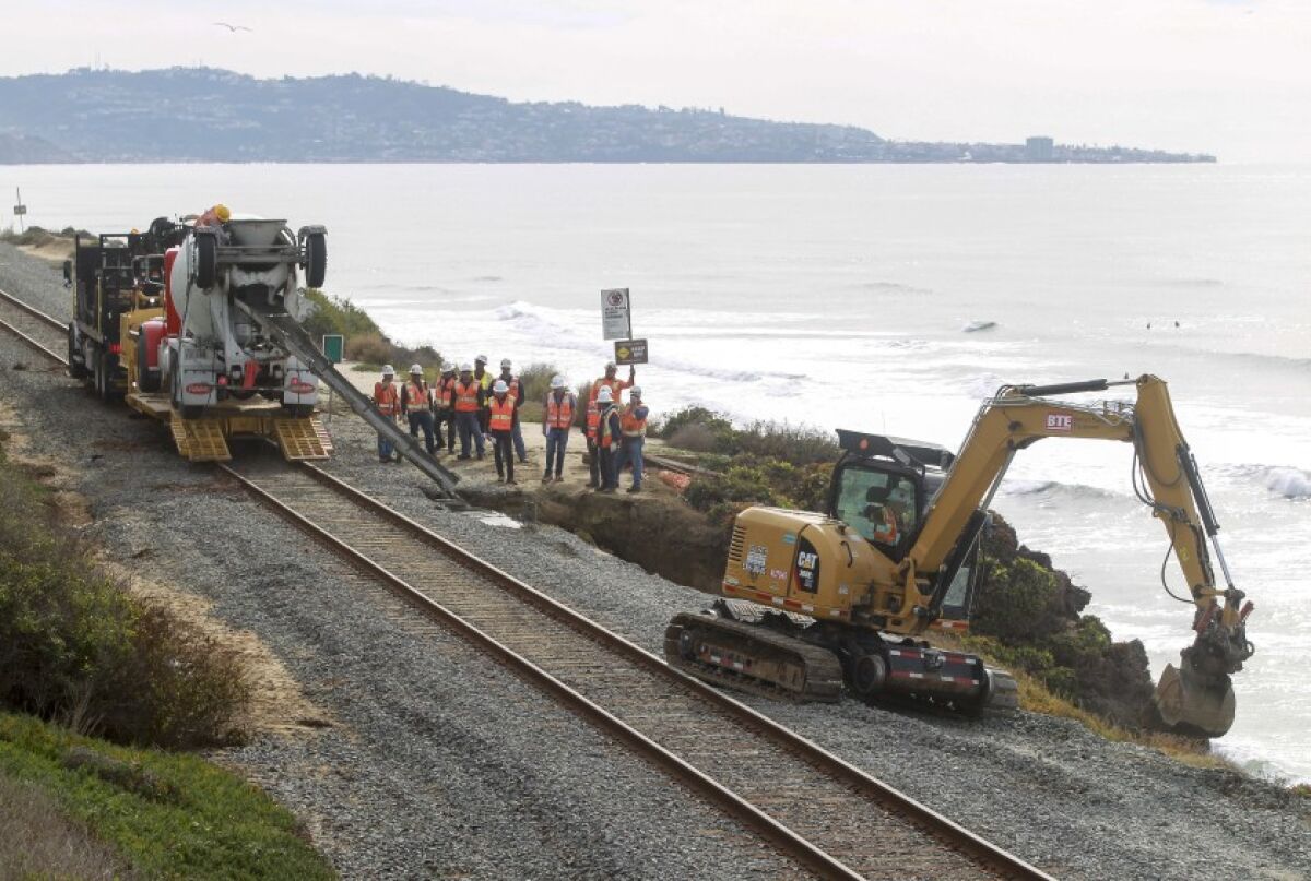 Workers repair the site of a bluff collapse next to the railroad tracks in Del Mar which was caused by a washout from the rains in November.