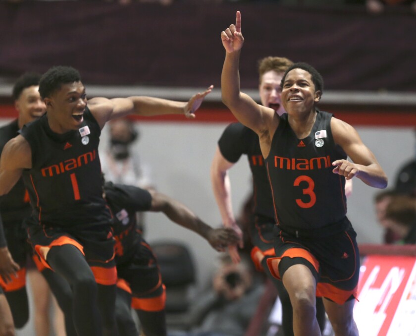 Miami's Charlie Moore (3) right, celebrates with Anthony Walker (1) left, and Sam Waardenburg (21) after making the winning shot at the buzzer to end second half of an NCAA college basketball game against Virginia Tech, Wednesday, Jan. 26 2022, in Blacksburg Va. (Matt Gentry/The Roanoke Times via AP)