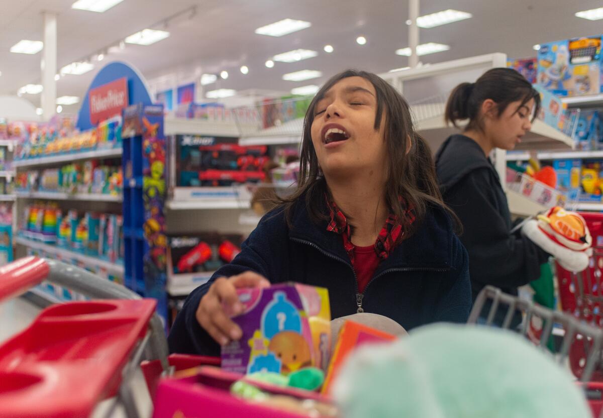Bethany Alcantara, 9, decides whether items in her cart will become Christmas gifts for her relatives.