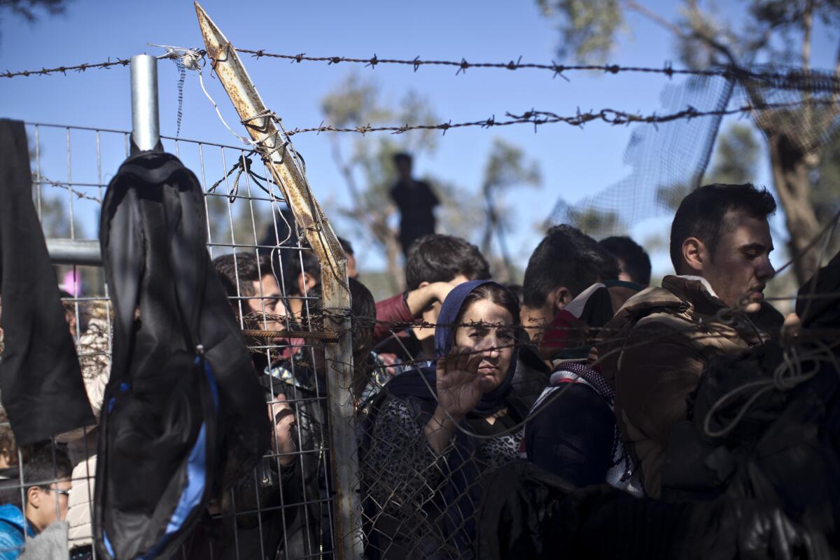 In this Nov. 4 photo, people wait in line to enter the migrant and refugee registration camp in Moria, on the island of Lesbos, Greece.