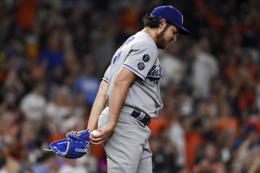 Dodgers starting pitcher Trevor Bauer walks back to the mound with his head down after giving up a home run