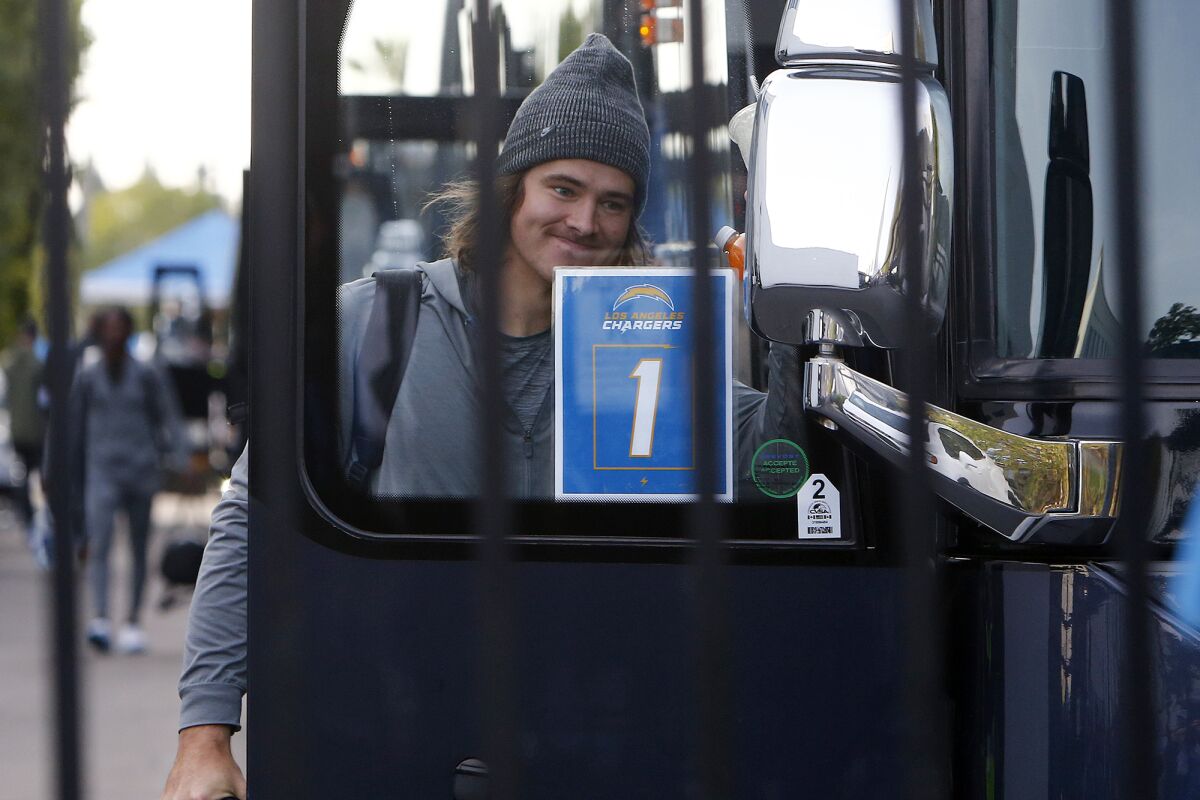 Quarterback Justin Herbert walks onto the first bus at the Hoag Performance Center in Costa Mesa on Friday morning.