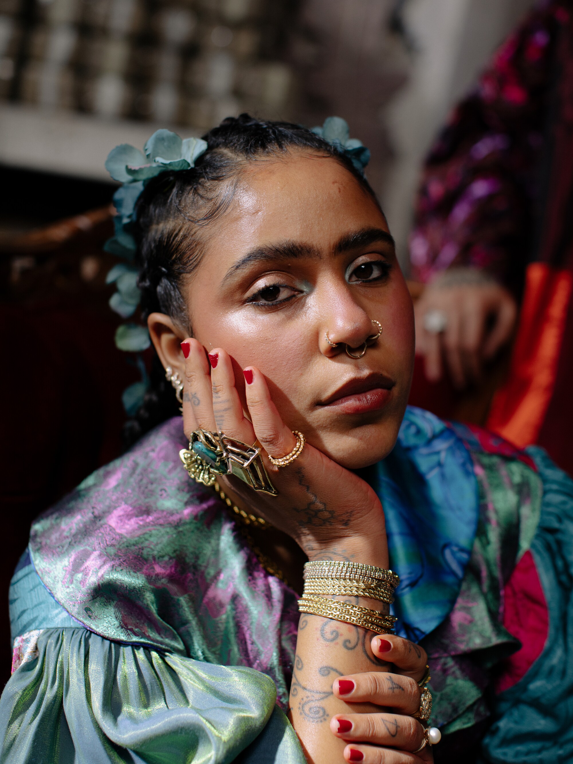 A woman with tattoos on her arm places her chin in hand for photograph