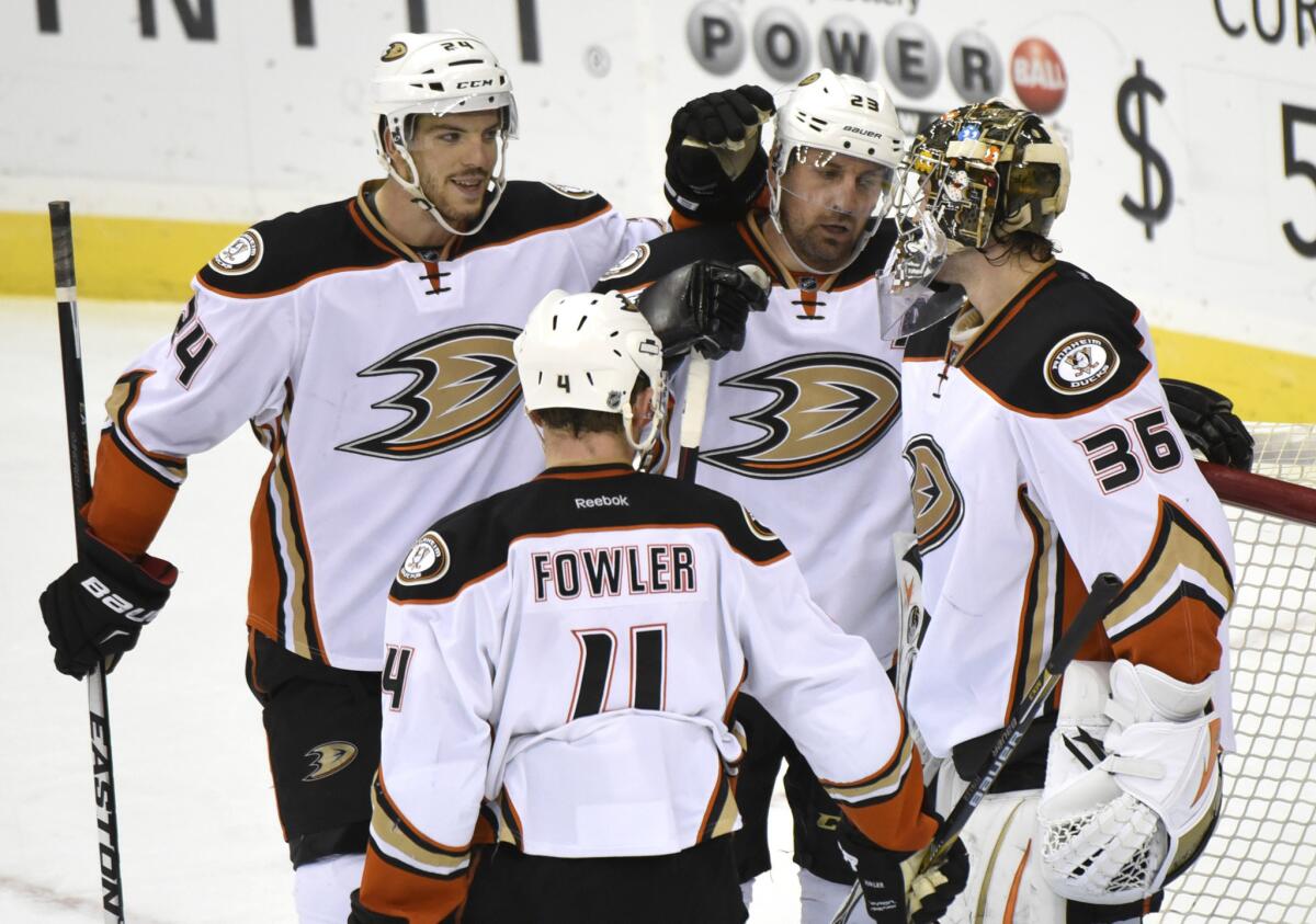 Ducks goaltender John Gibson, right, is congratulated by, from left, teammates Simon Despres, Cam Fowler and Francois Beauchemin after their 2-1 victory over the New Jersey Devils on Sunday.