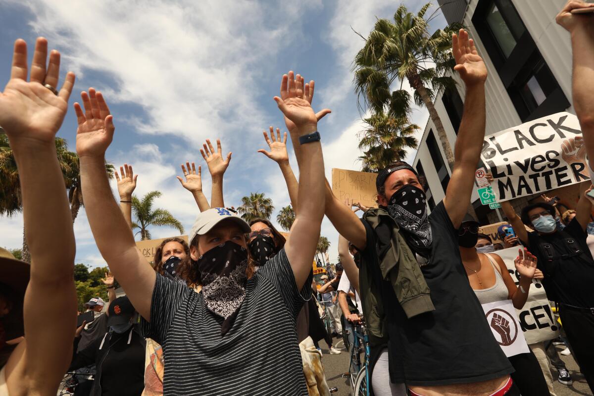 "Hands up. Don't shoot." Protesters chant and march with raised arms on Abbot Kinney Boulevard.