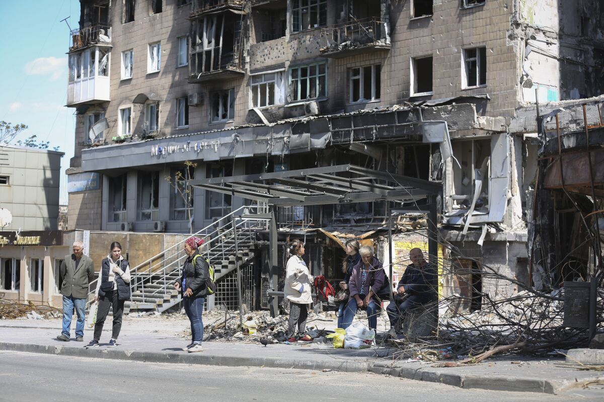 Residents next to destroyed buildings in Mariupol, Ukraine
