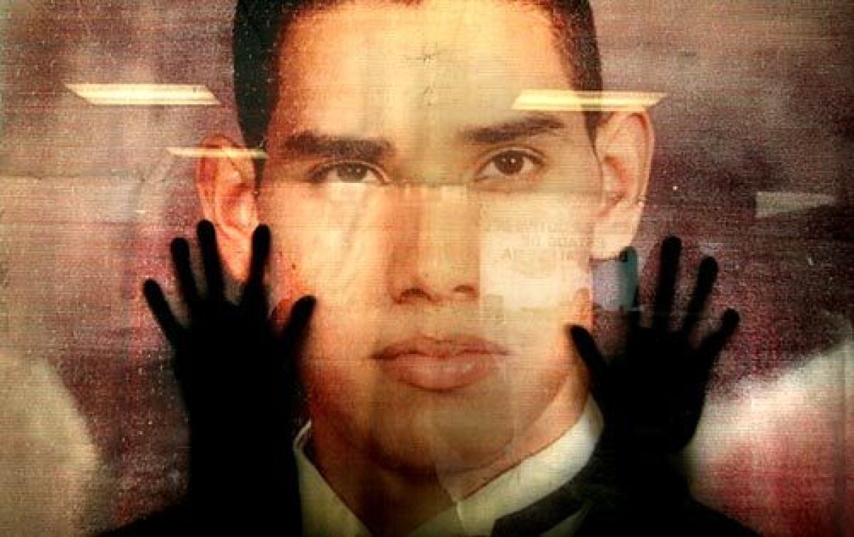 Seen from inside a Baja State government office, Fernando Ocegueda presses his hands on an enlarged photograph of his 23-year-old son. Ocegueda investigated his son's kidnapping on his own.