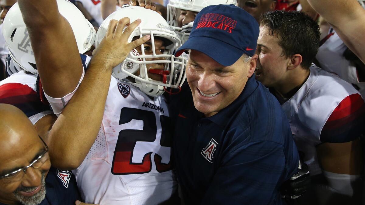 Arizona Coach Rich Rodriguez, right, celebrates with Austin Hill after the wide receiver's winning touchdown catch against California on Sept. 20. The Wildcats are off to a 5-0 start.