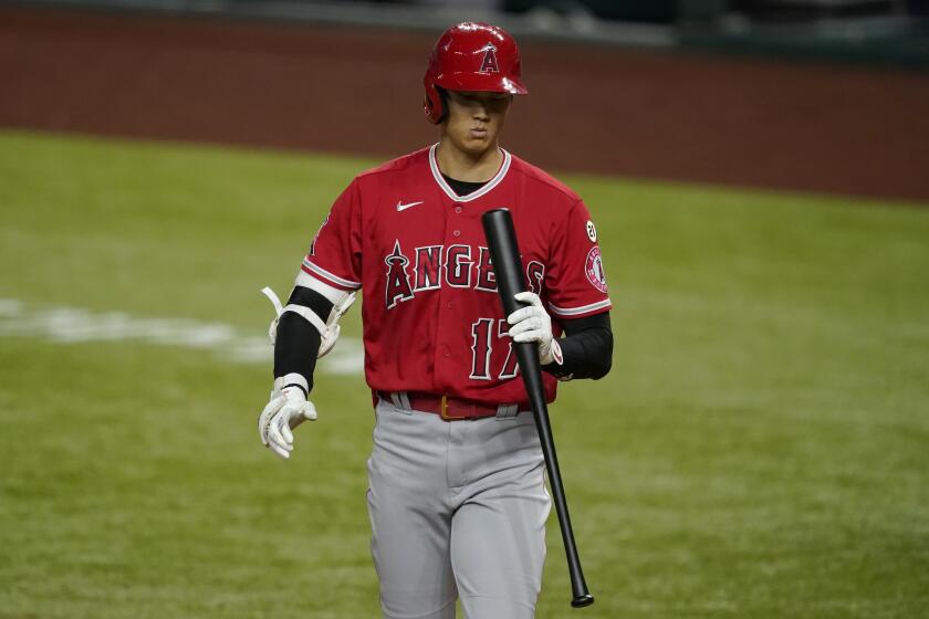 Los Angeles Angels' Shohei Ohtani looks down at his bat after striking out against the Texas Rangers during the fifth inning of a baseball game in Arlington, Texas, Wednesday, Sept. 9, 2020. (AP Photo/Tony Gutierrez)