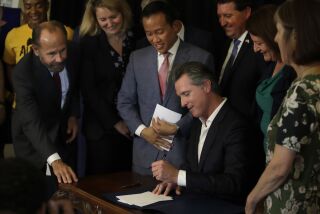 California Gov. Gavin Newsom signs bill AB 1482, Tuesday, Oct. 8, 2019, in Oakland, Calif. AB 1482 will cap rent increases at 5% each year plus inflation. The bill will also ban landlords from evicting tenants without just cause. (AP Photo/Ben Margot)