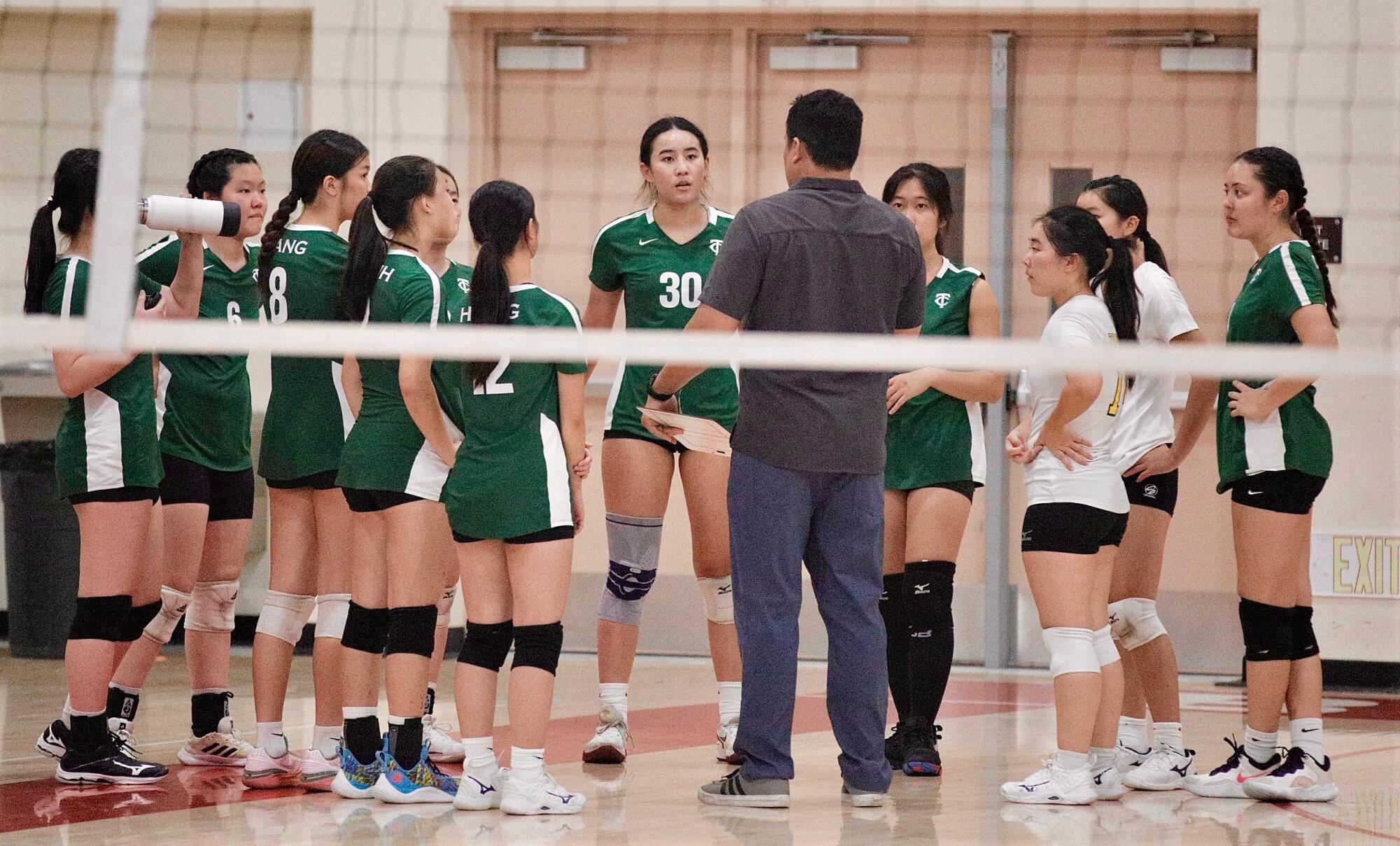 Taylor Yu (30) listens as her dad, Temple City head coach Nathan Yu, gives the team instructions during a timeout.