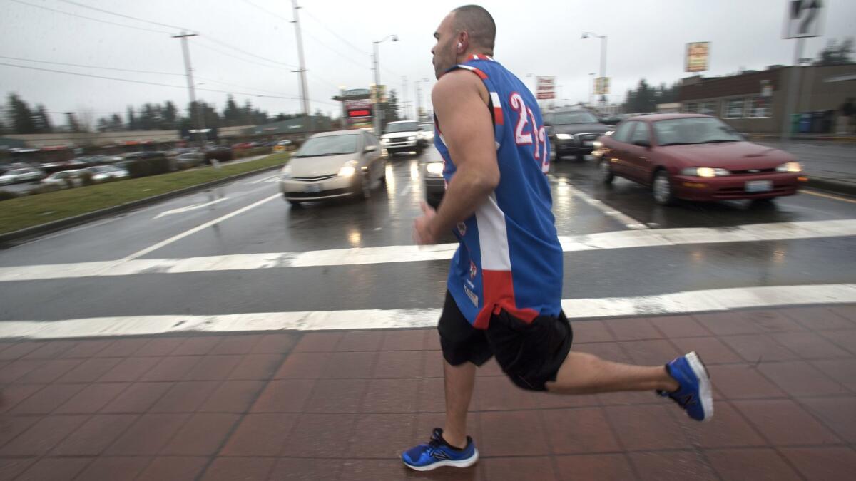 Lamont Thomas runs in Shoreline, Wash., dressed in one of the vintage basketball jerseys he collects.