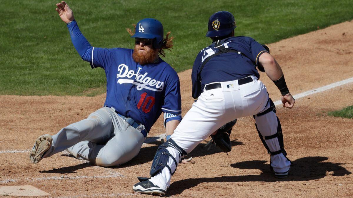 Dodgers' Justin Turner scores past Milwaukee Brewers catcher Jett Bandy during a spring training baseball game Sunday.