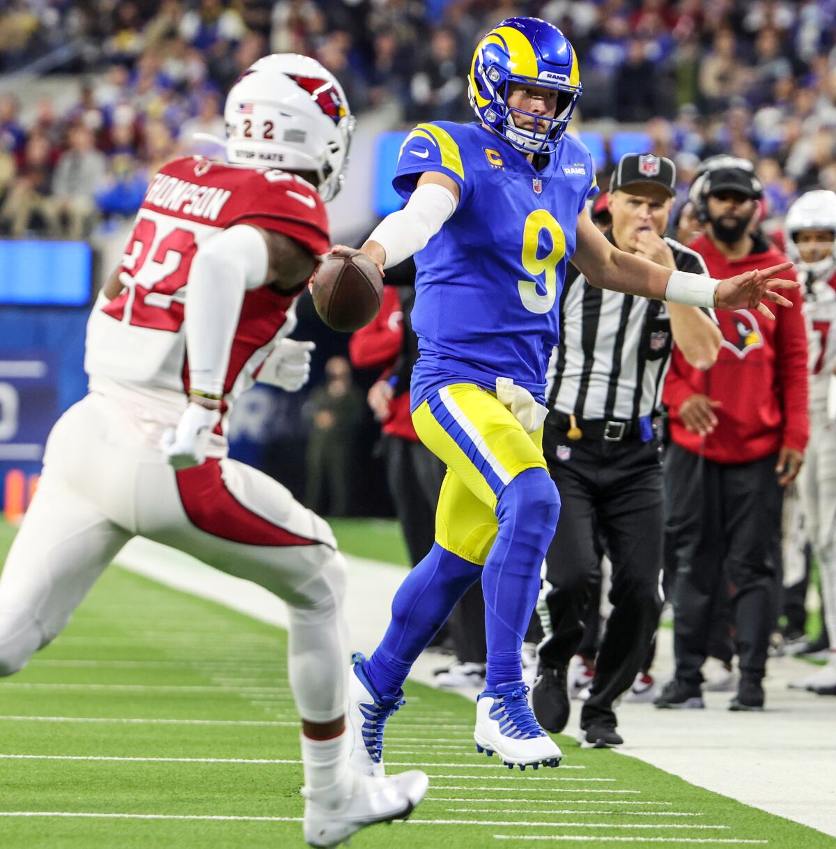 Rams quarterback Matthew Stafford  stretches for extra yardage on a third-quarter run as Arizona's Deionte Thompson pursues.