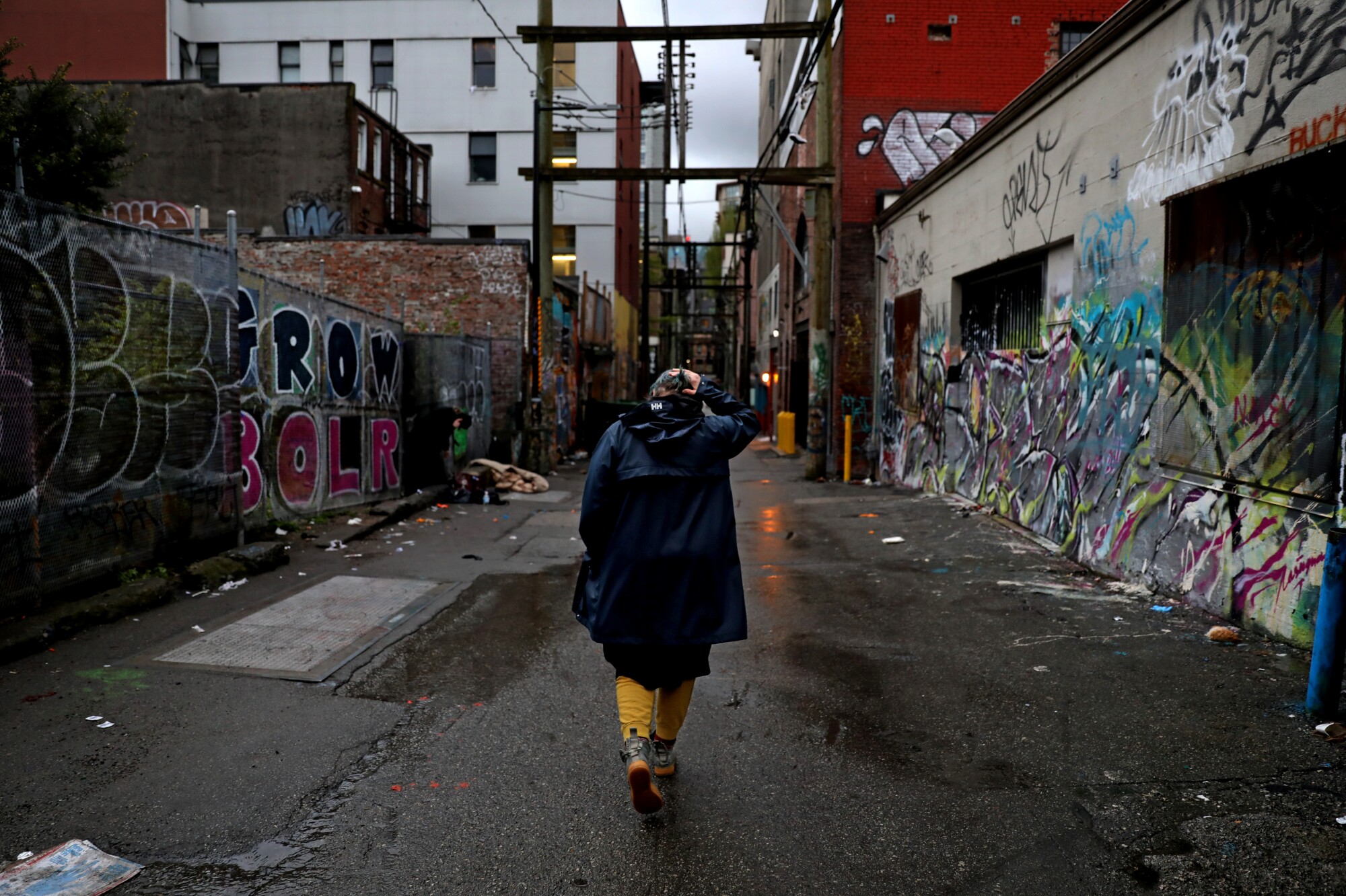 A woman walks down an alley