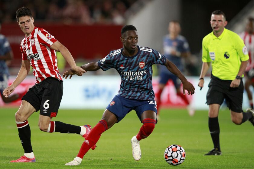 FILE - Brentford's Christian Norgaard vies for the ball with Arsenal's Folarin Balogun, center, during the English Premier League soccer match between Brentford and Arsenal at the Brentford Community Stadium in London, on Aug. 13, 2021. The United States can select Balogun after the England Under-21 forward who has starred in the French league opted to represent the 2026 World Cup co-host. FIFA said on Tuesday May 16, 2023 it approved a request by the U.S. Soccer Federation to change Balogun’s national eligibility from England. The 21-year-old New York-born player also was eligible for Nigeria. (AP Photo/Ian Walton, File)