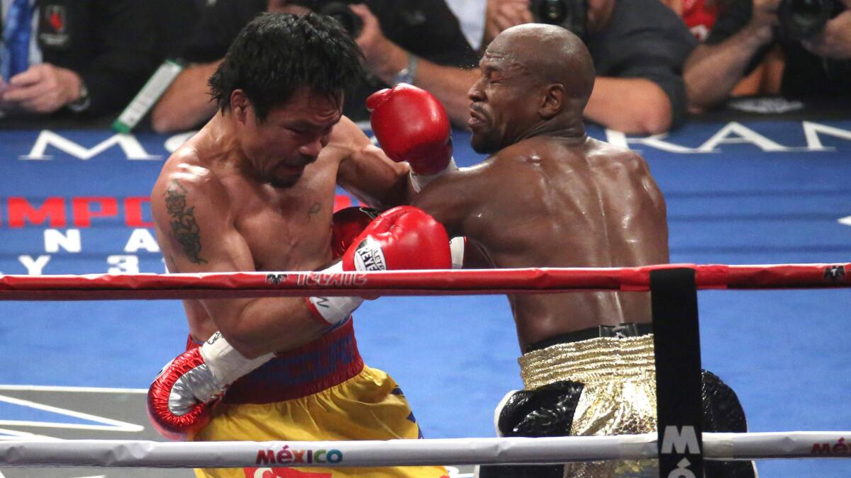Manny Pacquiao, left, exchanges blows with Floyd Mayweather Jr. during Mayweather's welterweight title victory at the MGM Grand Hotel in Las Vegas on May 2.