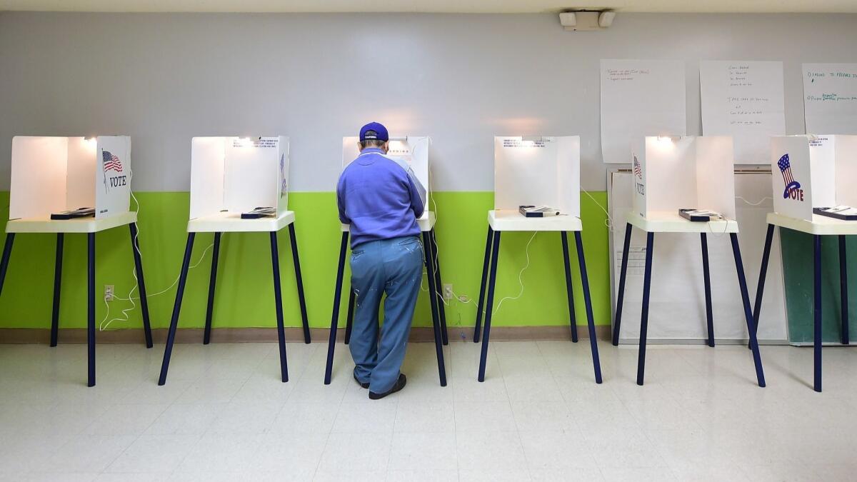 A voter casts his vote at a polling station in Pasadena on November 4, 2014.
