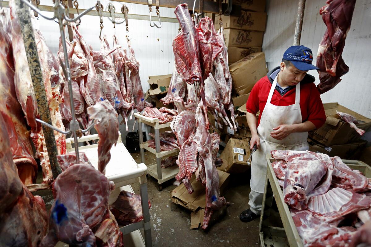 A worker looks for a cut of meat at Jerusalem Halal Meats on Hillcroft Avenue in southwest Houston.
