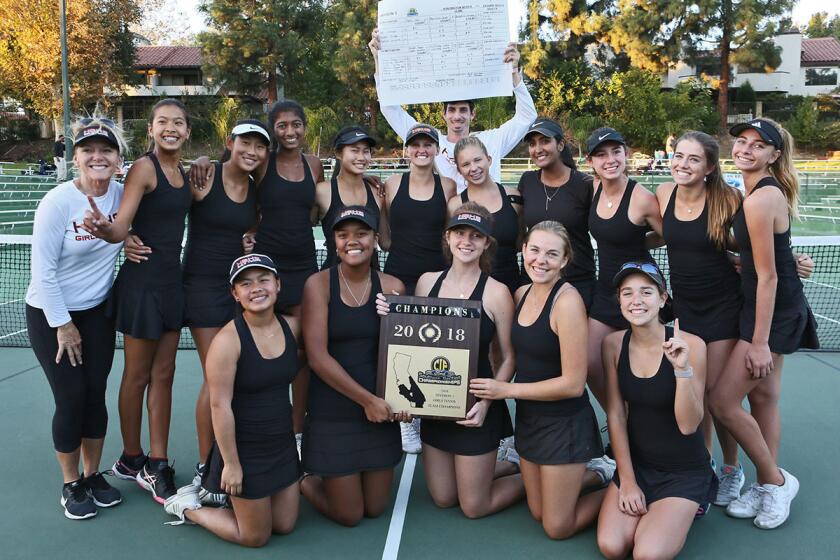 The Huntington Beach High girls' tennis team celebrates its CIF Southern Section Division 3 championship win against Laguna Beach at the Claremont Club on Friday.