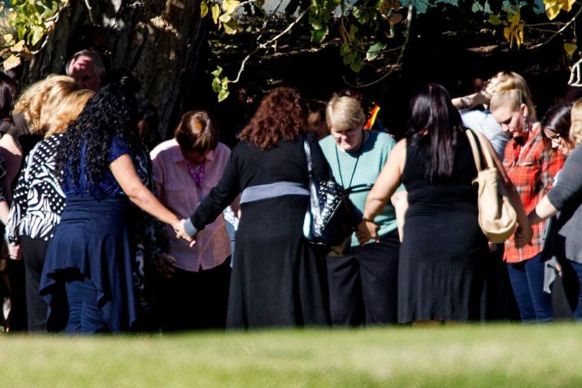 Evacuated workers pray in a circle on the fairway of San Bernardino Golf Club, across the street from where they narrowly escaped a mass shooting at the Inland Regional Center. This was among the first of several important photos taken by Gina Ferazzi on Dec. 2, 2015.