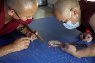 Tibetan Buddhist monks, on a visit to North County from the Gaden Shartse Cultural Foundation in Southern India, make a mandala that will cover most of the table it is on when completed, at the Unitarian Universalist Fellowship of San Dieguito in Solana Beach Wednesday. photo by Bill Wechter