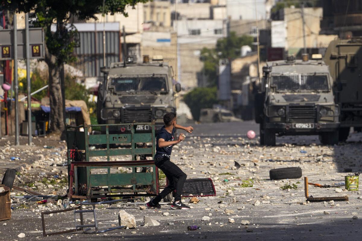 Palestinian youth preparing to throw a rock at Israeli forces