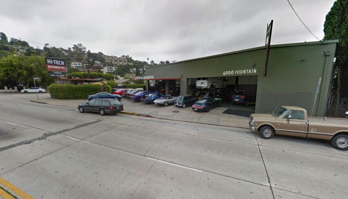 An auto repair shop with cars parked outside
