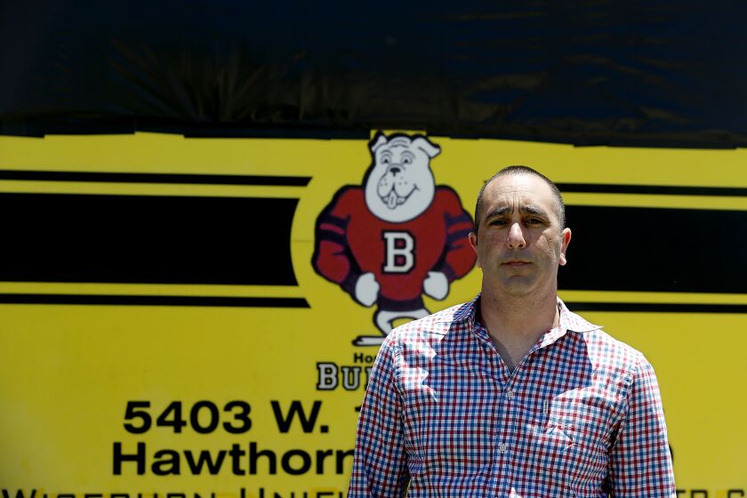 HAWTHORNE, CA - JULY 16, 2020. Wiseburn Unified School District Superintendent Blake Silvers stands in front a sign where the name of former California Gov.Peter Burnett has been covered with black plastic and duct tape. Peter Burnett Elementary School in Hawthorne has temporaily changed its name to 138th Street School after community members complained that Burnett committed violence against Black, Indigenous and Chinese people. (Luis Sinco / Los Angeles Times)