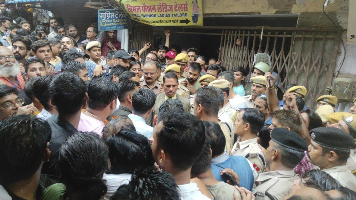 Crowd outside shop belonging to slain tailor