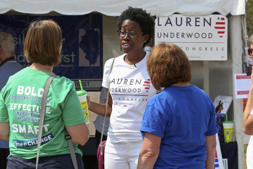 In this Aug. 12, 2018, photo, rookie Democratic candidate Lauren Underwood talks with supporters in Lindenhurst, Ill. If elected to the U.S. House, Underwood would be the first woman and first minority to represent the predominantly white district once represented by GOP House Speaker Dennis Hastert. (AP Photo/Teresa Crawford)